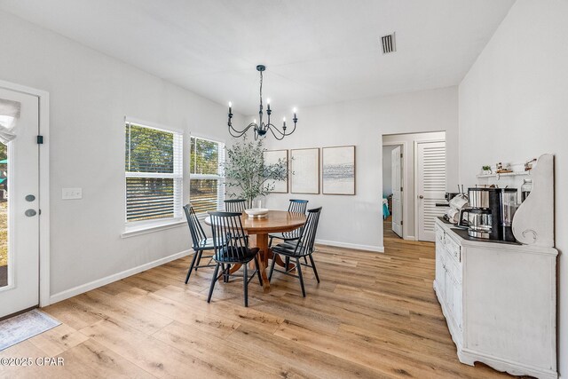 dining space featuring a notable chandelier and light wood-type flooring