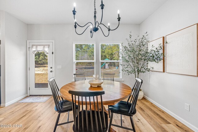 dining space featuring an inviting chandelier and light hardwood / wood-style flooring