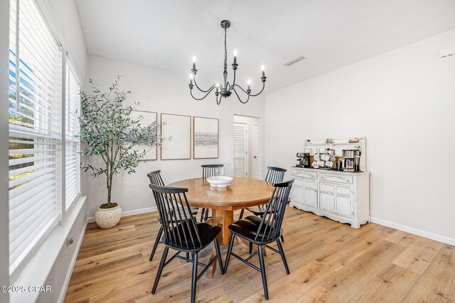 dining area featuring an inviting chandelier and light hardwood / wood-style flooring