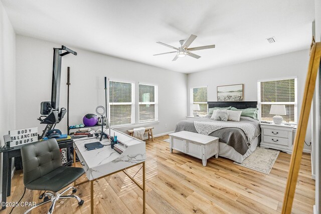 bedroom featuring multiple windows, light hardwood / wood-style flooring, and ceiling fan