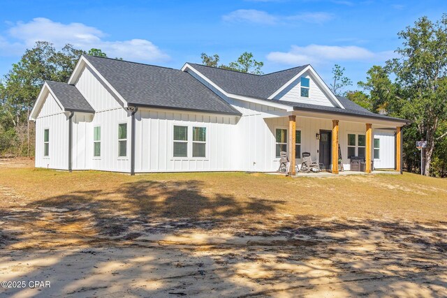 modern farmhouse style home featuring a front yard and covered porch