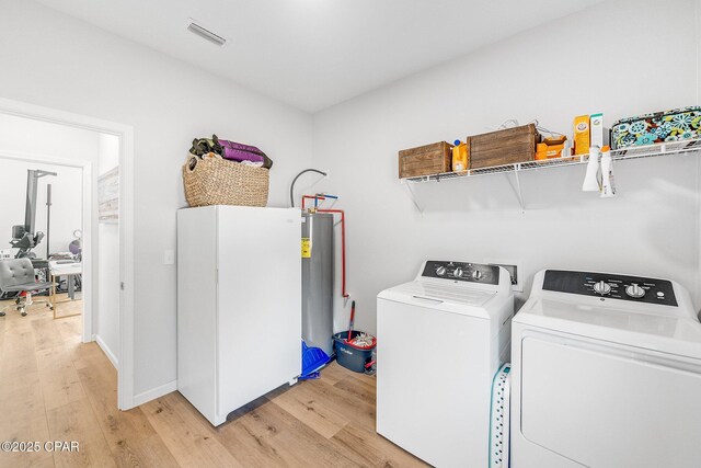 washroom featuring washing machine and dryer and light hardwood / wood-style floors