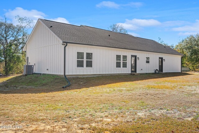 back of house with cooling unit and a yard