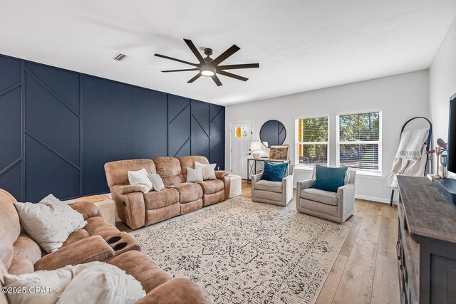 living room with light hardwood / wood-style floors and ceiling fan