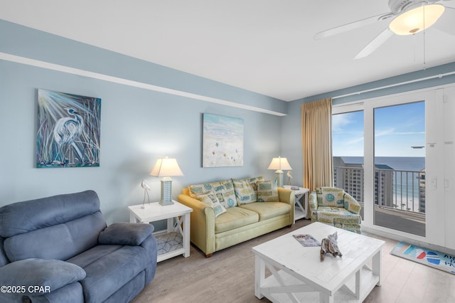 living room featuring a water view, ceiling fan, and wood-type flooring