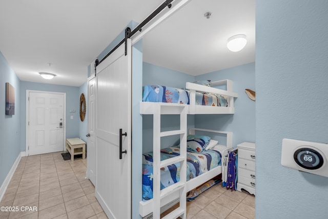 tiled bedroom featuring a barn door