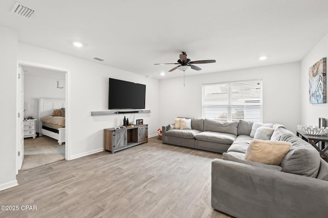 living room featuring ceiling fan and light hardwood / wood-style flooring