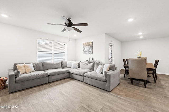 living room featuring ceiling fan and light hardwood / wood-style flooring