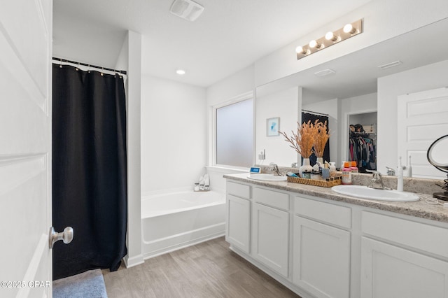 bathroom featuring vanity, hardwood / wood-style floors, and a bathtub