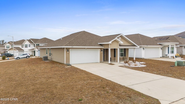 ranch-style house with a garage and central air condition unit