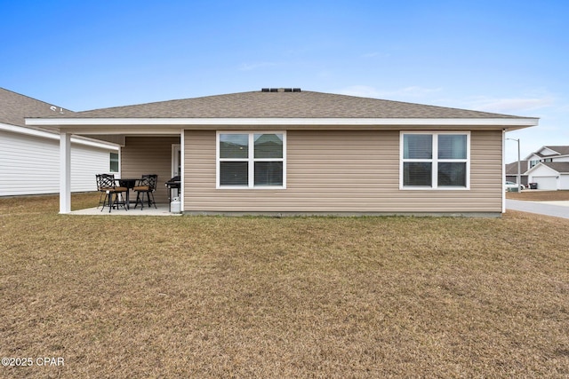 rear view of house with a yard and a patio