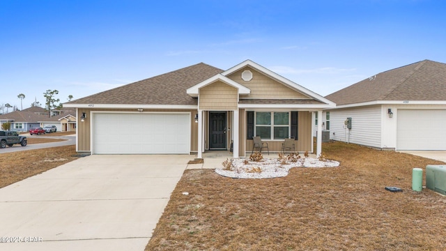 ranch-style home with central AC unit, a garage, and covered porch