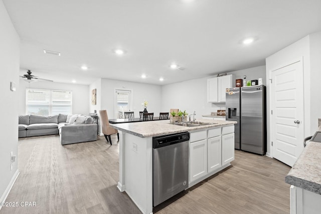 kitchen featuring sink, white cabinetry, light hardwood / wood-style flooring, an island with sink, and stainless steel appliances