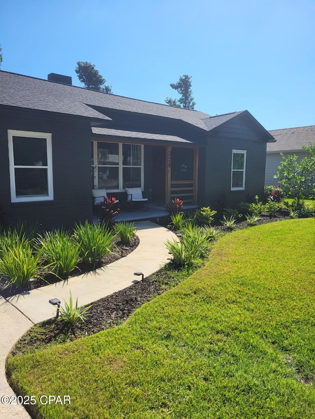 single story home featuring covered porch and a front yard