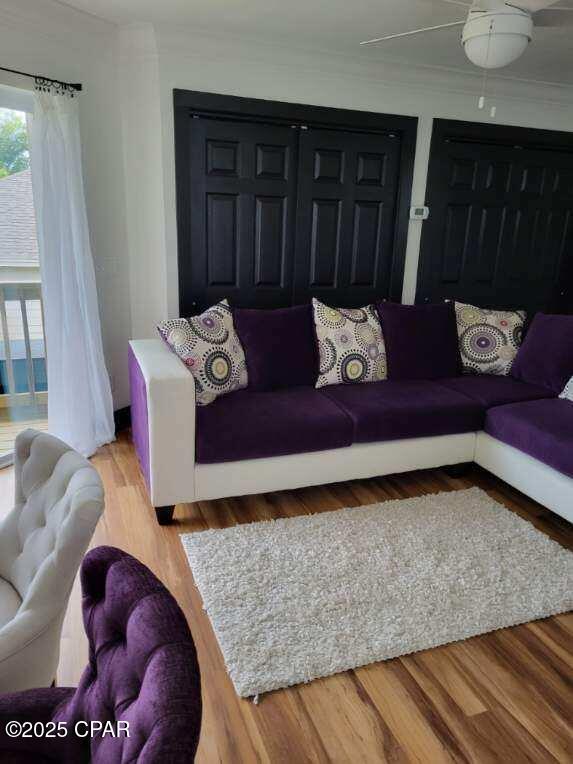 living room with wood-type flooring and crown molding