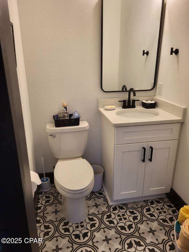 bathroom featuring tile patterned flooring, vanity, and toilet