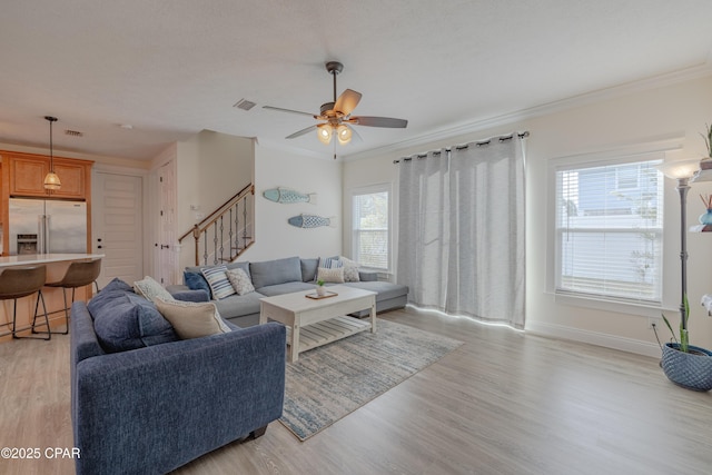 living room with crown molding, light hardwood / wood-style floors, and ceiling fan