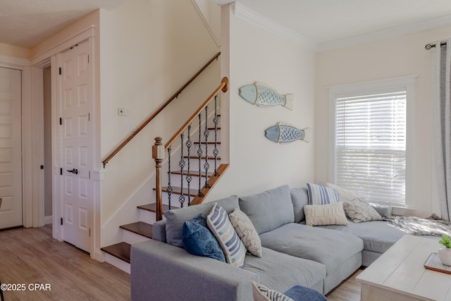 living room with crown molding and light wood-type flooring