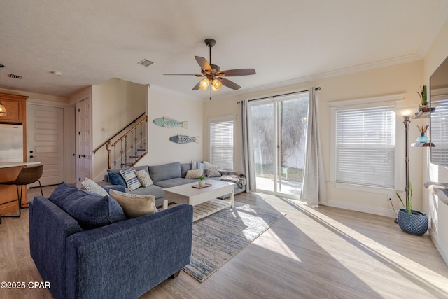 living room featuring crown molding, ceiling fan, and light wood-type flooring