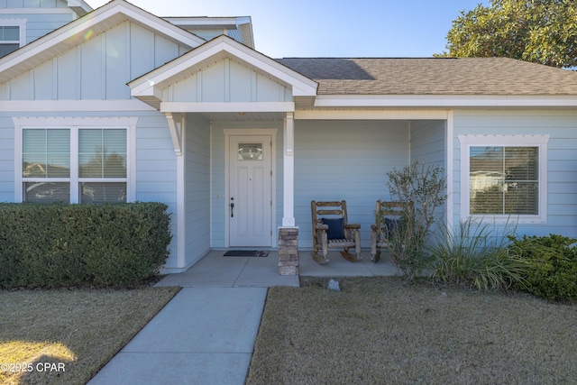 entrance to property featuring covered porch and a lawn