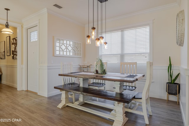 dining space featuring hardwood / wood-style flooring and ornamental molding