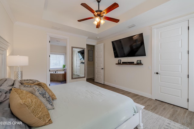 bedroom featuring crown molding, a tray ceiling, light hardwood / wood-style floors, and ceiling fan