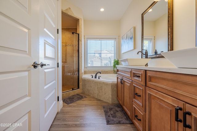 bathroom featuring a healthy amount of sunlight, shower with separate bathtub, and wood-type flooring