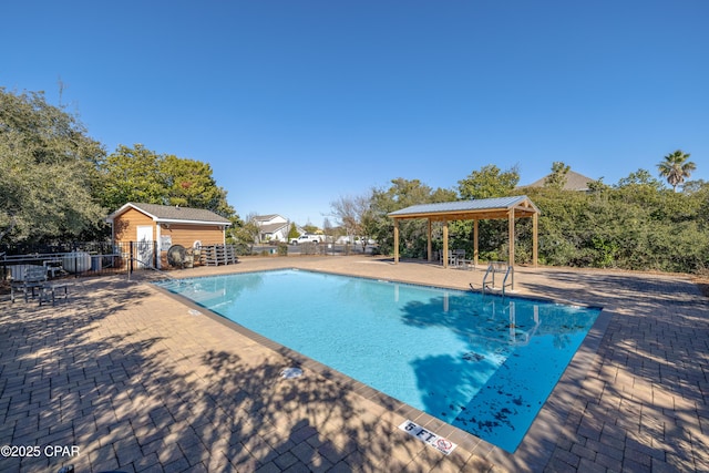 view of swimming pool with a patio and an outbuilding