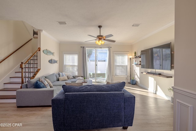 living room with crown molding, light hardwood / wood-style flooring, and ceiling fan