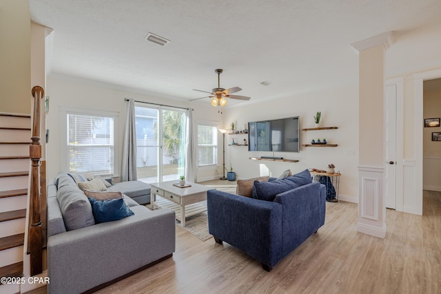 living room featuring crown molding, light hardwood / wood-style floors, and ceiling fan