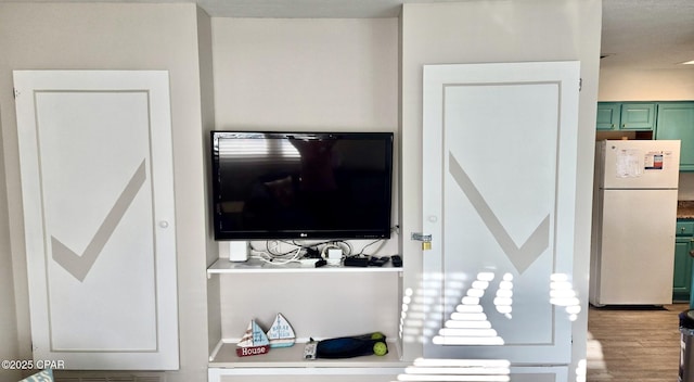 interior details featuring freestanding refrigerator and wood finished floors