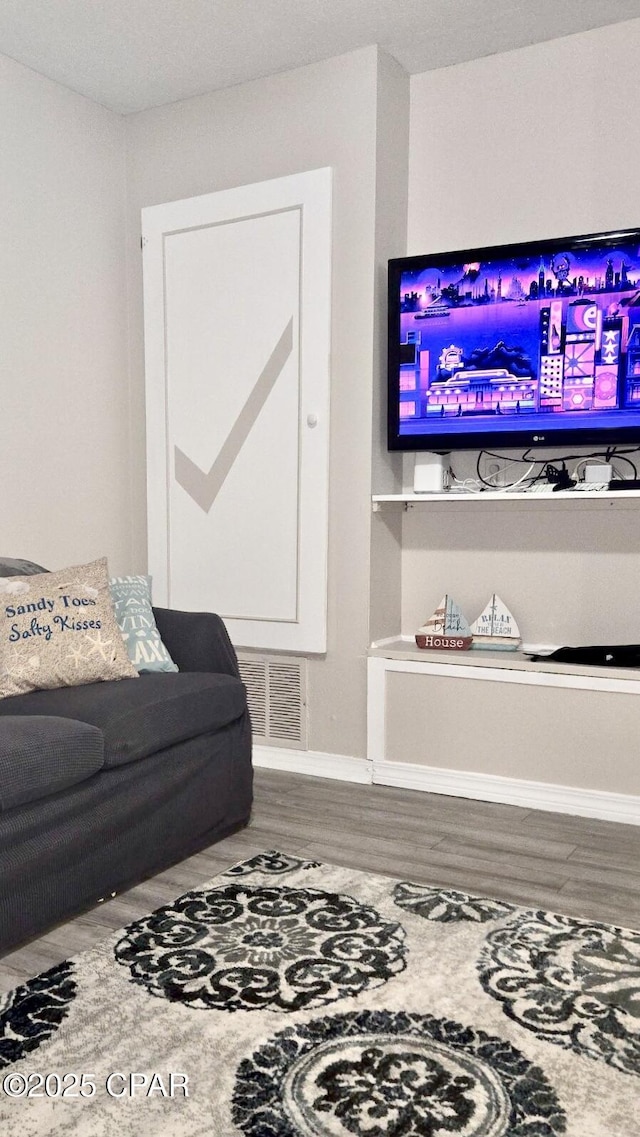 living area with wood finished floors and visible vents