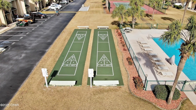 view of property's community featuring shuffleboard, fence, and a pool