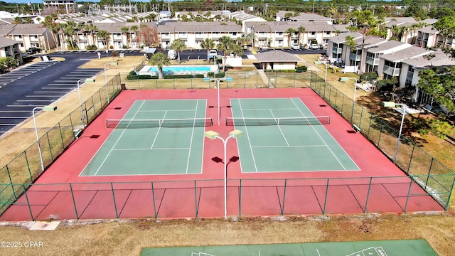 view of sport court with fence and a residential view