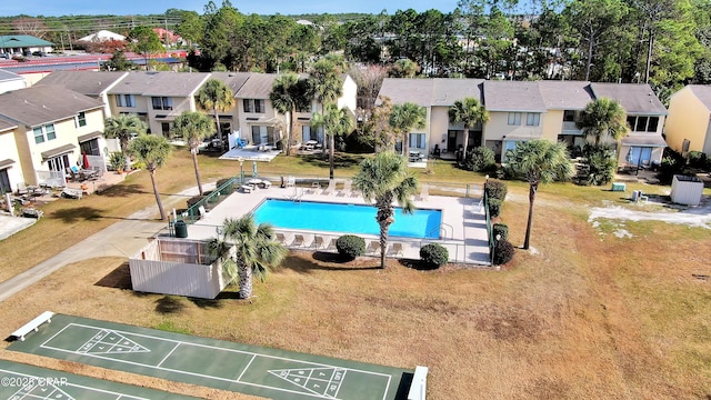 pool with a residential view, fence, and shuffleboard