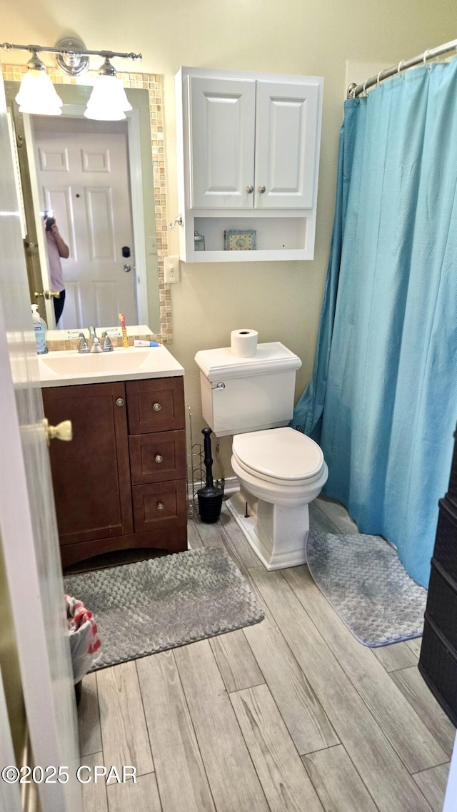 full bathroom with curtained shower, vanity, toilet, and wood tiled floor