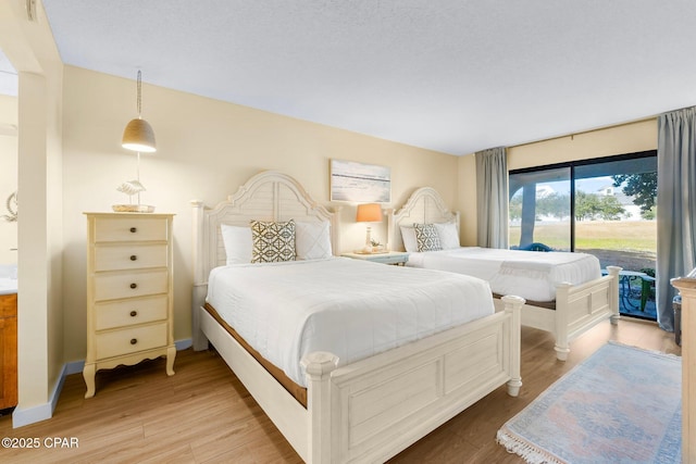 bedroom with access to exterior and hardwood / wood-style floors