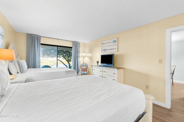bedroom with access to outside and light hardwood / wood-style floors