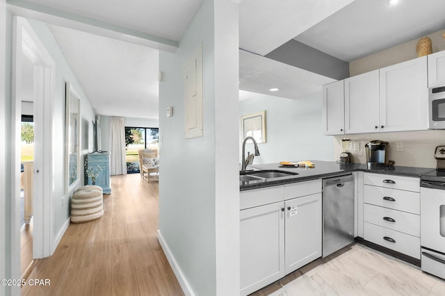 kitchen featuring sink, light hardwood / wood-style flooring, appliances with stainless steel finishes, white cabinets, and kitchen peninsula