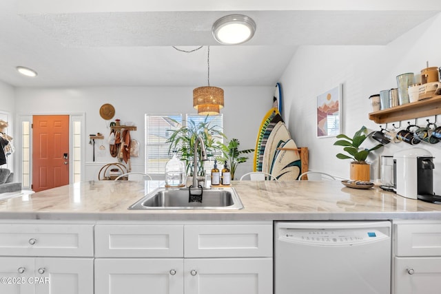 kitchen featuring sink, white cabinetry, light stone counters, hanging light fixtures, and white dishwasher