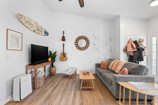 living room featuring light hardwood / wood-style flooring and ceiling fan