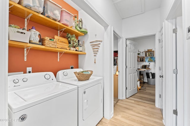 laundry area featuring washer and clothes dryer and light hardwood / wood-style floors