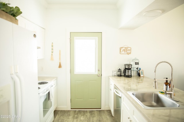 kitchen featuring white cabinetry, sink, ornamental molding, white appliances, and light hardwood / wood-style flooring