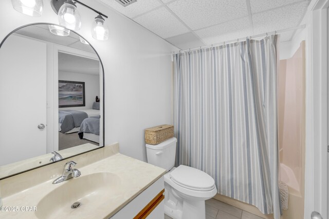 full bathroom with shower / bath combination with curtain, tile patterned flooring, vanity, toilet, and a drop ceiling