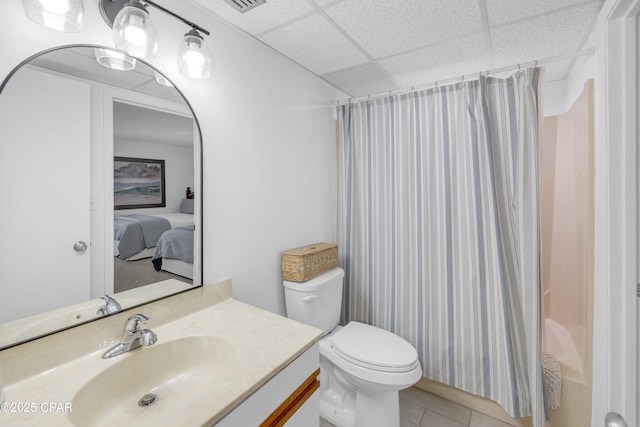 bathroom with vanity, a drop ceiling, tile patterned floors, toilet, and shower / tub combo with curtain