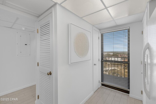 kitchen with stacked washer / dryer, white cabinetry, a paneled ceiling, and white appliances