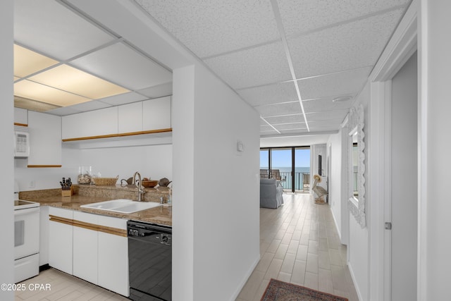 kitchen with a sink, a drop ceiling, white cabinets, white appliances, and open shelves