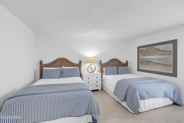 bedroom with light hardwood / wood-style floors and a textured ceiling