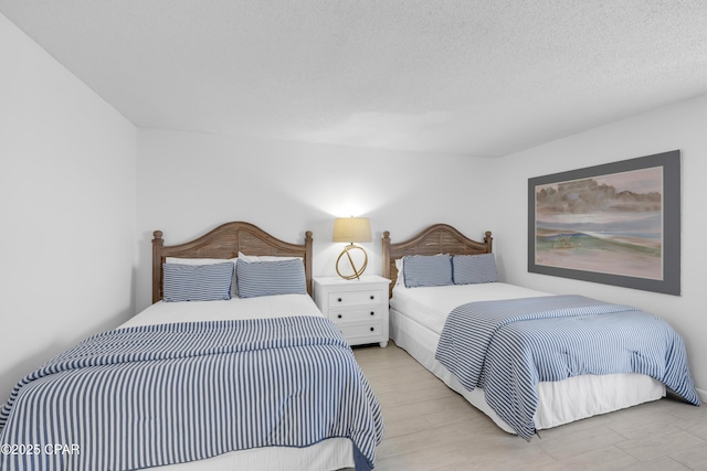 bedroom with a textured ceiling and wood finished floors