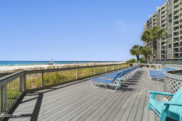 wooden deck featuring a view of the beach and a water view